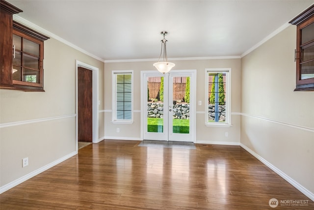 unfurnished dining area featuring wood finished floors, baseboards, and ornamental molding