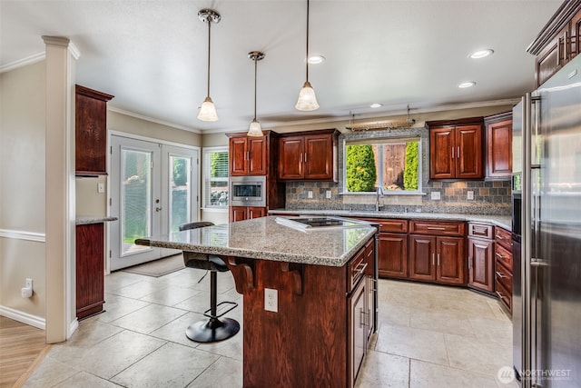 kitchen featuring appliances with stainless steel finishes, ornamental molding, tasteful backsplash, a sink, and a breakfast bar