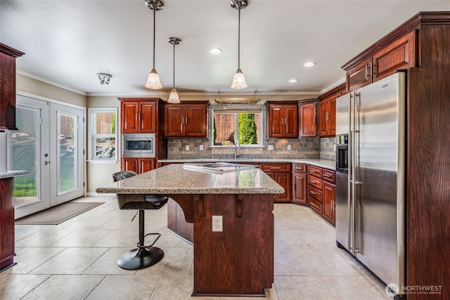 kitchen featuring stainless steel appliances, ornamental molding, backsplash, pendant lighting, and a breakfast bar