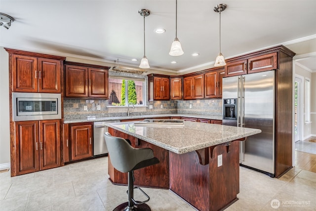kitchen featuring built in appliances, crown molding, a kitchen island, tasteful backsplash, and a kitchen breakfast bar
