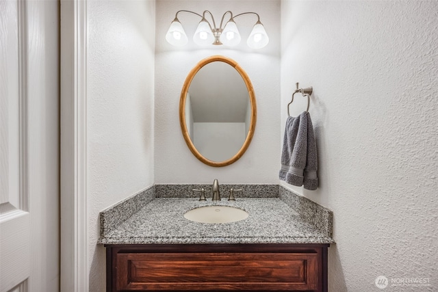 bathroom featuring vanity and a textured wall