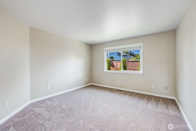 carpeted empty room with baseboards