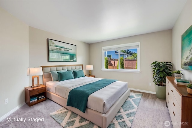 bedroom featuring light colored carpet and baseboards