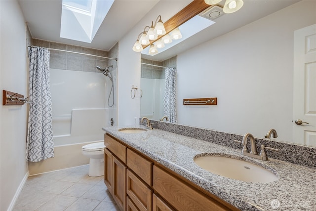 full bathroom with a skylight, tile patterned floors, toilet, and double vanity