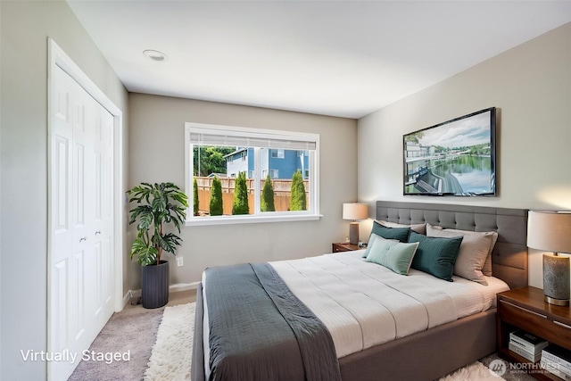 carpeted bedroom featuring a closet and baseboards