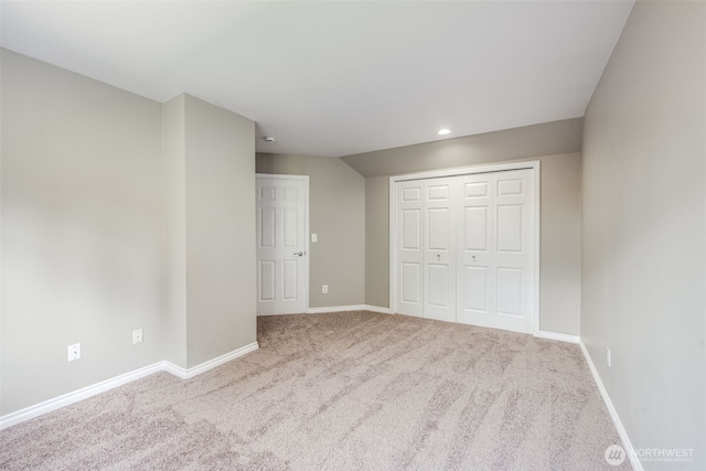 unfurnished bedroom featuring carpet flooring, baseboards, a closet, and recessed lighting