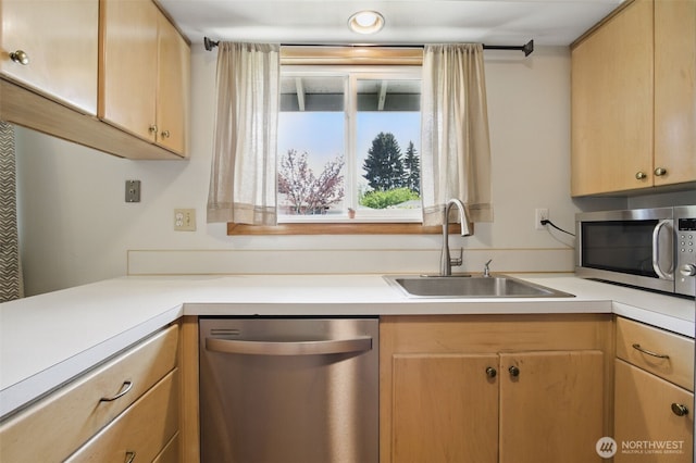 kitchen featuring a sink, light countertops, light brown cabinets, and stainless steel appliances