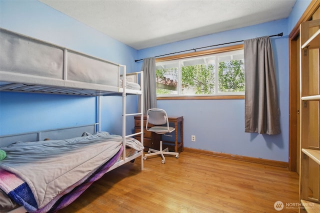 bedroom featuring baseboards and wood finished floors