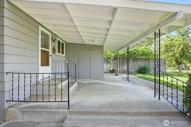view of patio / terrace featuring fence and an attached carport
