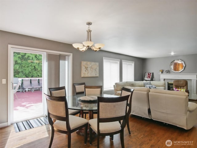 dining room featuring dark wood-style flooring, an inviting chandelier, and a wealth of natural light