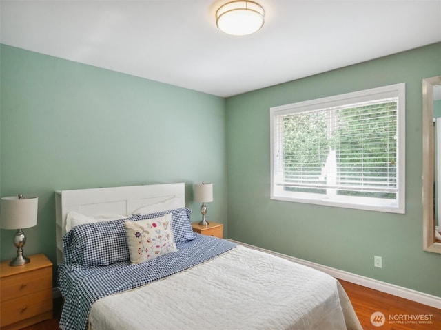 bedroom featuring baseboards and wood finished floors