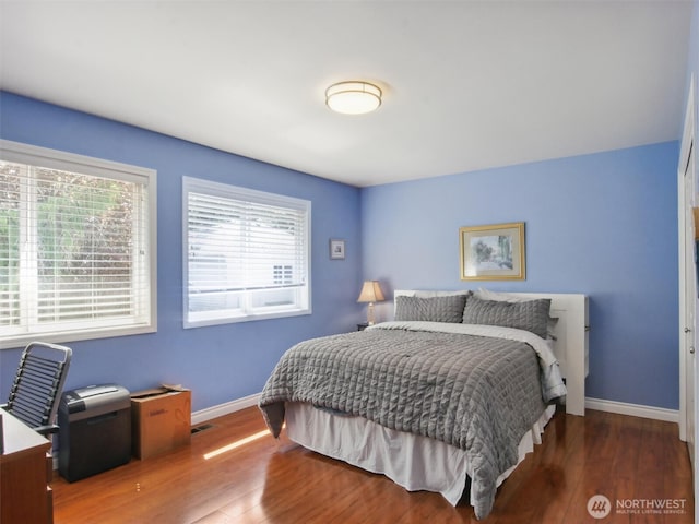 bedroom featuring baseboards and wood finished floors