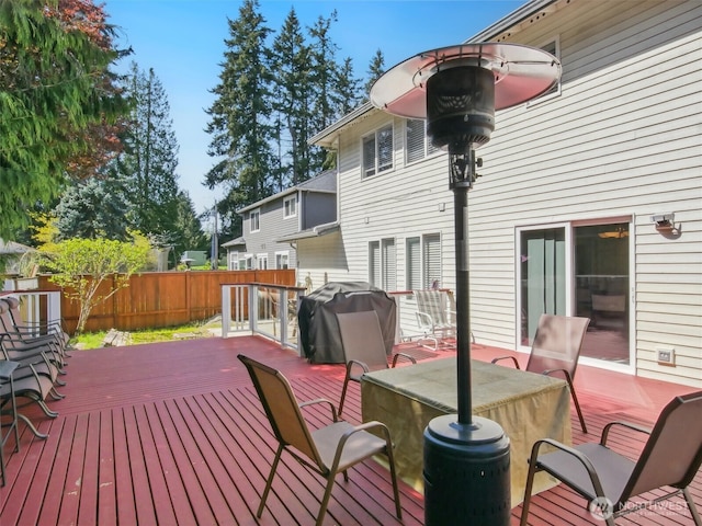 wooden terrace featuring outdoor dining area, fence, and grilling area