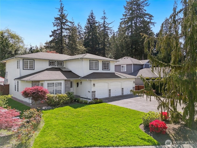 traditional-style house with concrete driveway, stone siding, a front yard, and a garage