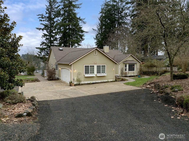view of front of home featuring an attached garage, a chimney, and concrete driveway