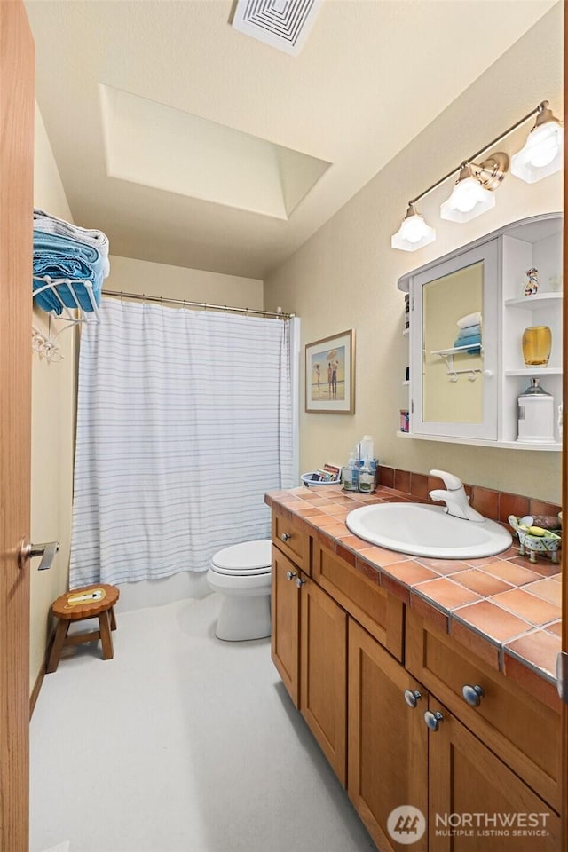 full bathroom with toilet, a skylight, visible vents, and vanity