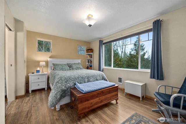 bedroom with baseboards and wood finished floors