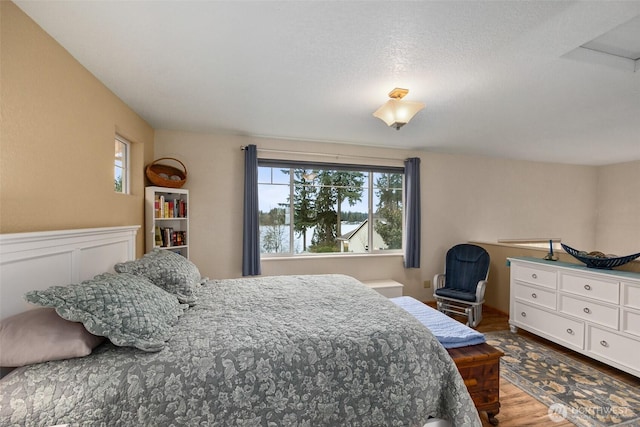 bedroom with wood finished floors and multiple windows