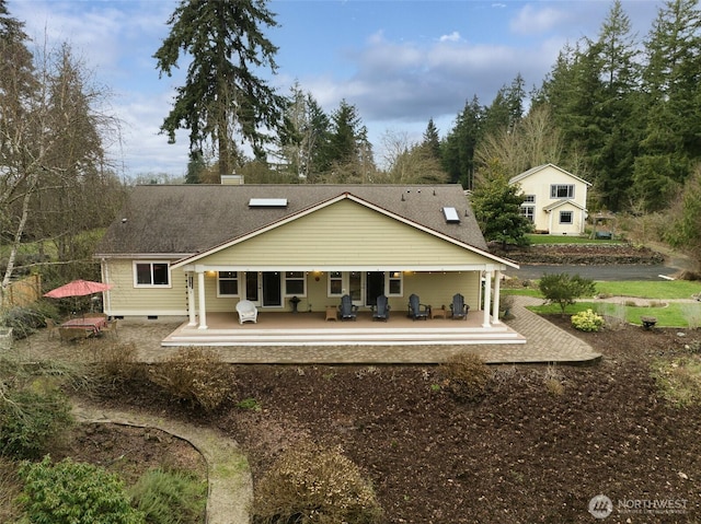 rear view of property featuring roof with shingles, covered porch, and crawl space