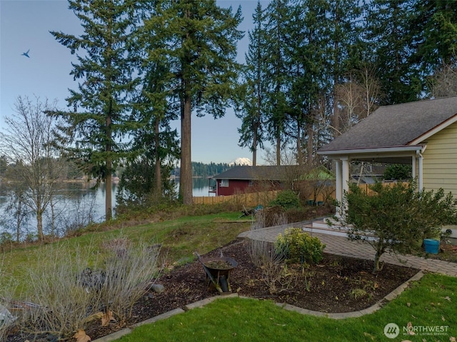 view of yard featuring a water view and fence