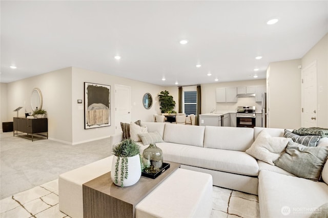 living room with light colored carpet, recessed lighting, and baseboards
