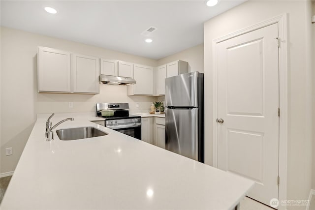 kitchen with recessed lighting, light countertops, under cabinet range hood, a sink, and stainless steel appliances