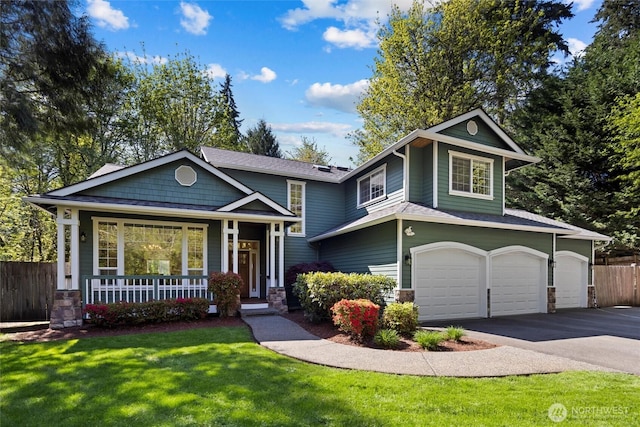 view of front facade featuring a front lawn, fence, covered porch, an attached garage, and driveway