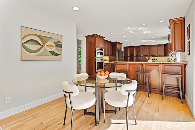 dining area featuring recessed lighting, baseboards, and light wood-type flooring