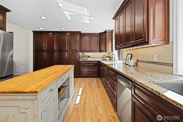 kitchen with wainscoting, light wood finished floors, wood counters, stainless steel appliances, and recessed lighting