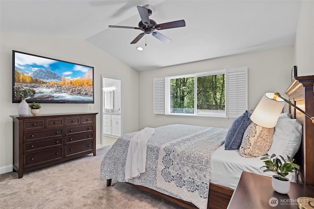 bedroom with ceiling fan, baseboards, lofted ceiling, light carpet, and ensuite bath