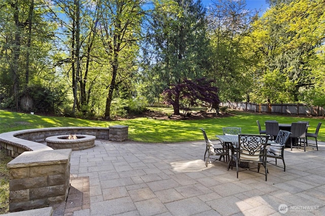 view of patio featuring outdoor dining area, a fire pit, and fence