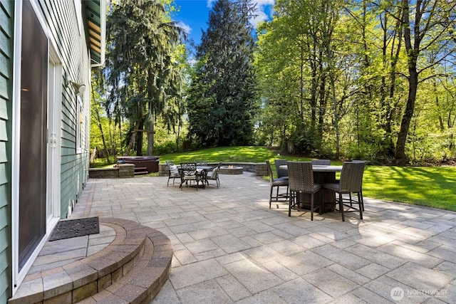 view of patio with outdoor dining space and a hot tub