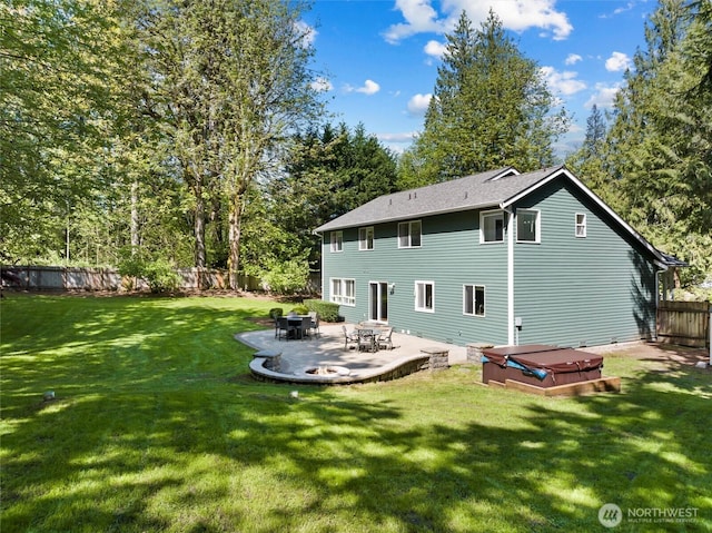 back of property with a covered hot tub, a yard, a fenced backyard, and a patio area