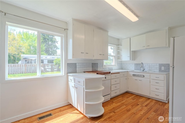 kitchen with open shelves, a sink, white appliances, light countertops, and tasteful backsplash