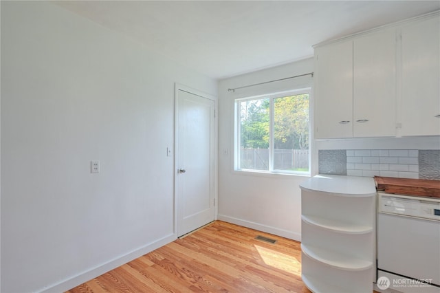unfurnished office featuring light wood-type flooring and baseboards