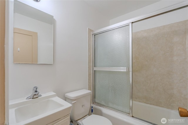 full bath with enclosed tub / shower combo, toilet, and vanity