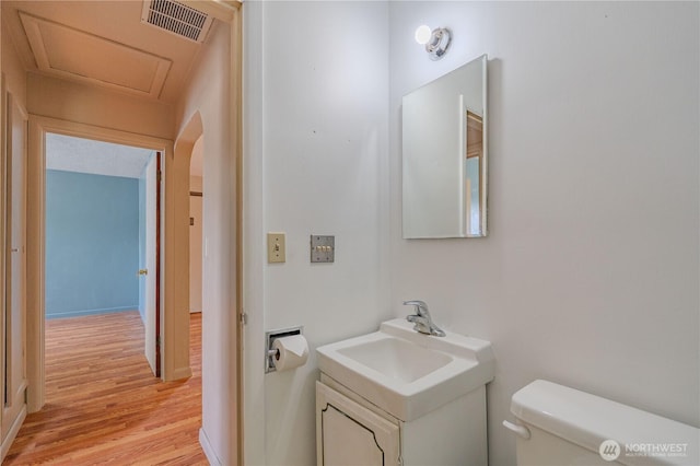 bathroom featuring wood finished floors, toilet, and vanity