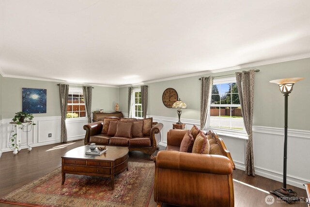 living area with plenty of natural light, crown molding, wood finished floors, and a wainscoted wall