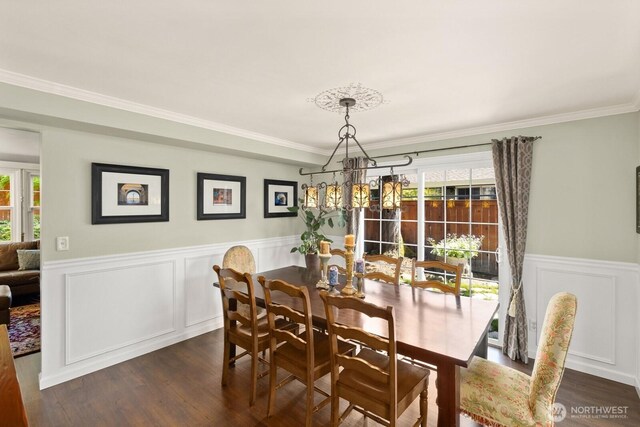 dining space featuring wainscoting, an inviting chandelier, dark wood-style floors, and a healthy amount of sunlight