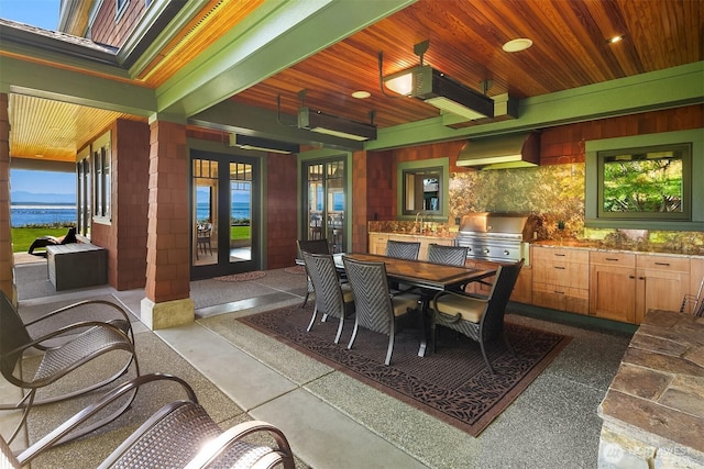5844 Mutiny Bay Rd, Freeland, WA 98249 - dining space with french doors, dark speckled floor, wood ceiling, and a wealth of natural light