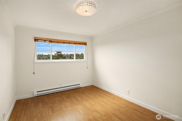 unfurnished room with a baseboard heating unit, ornamental molding, light wood-type flooring, and baseboards