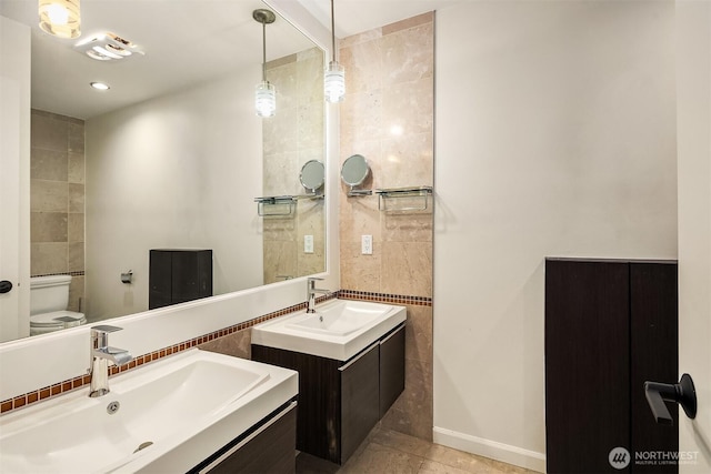 bathroom with two vanities, toilet, tile patterned flooring, and baseboards