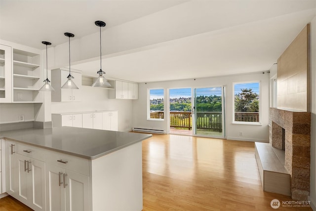 kitchen with a baseboard radiator, open shelves, white cabinetry, and light wood finished floors