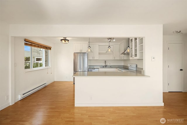 kitchen with a baseboard heating unit, electric range, freestanding refrigerator, a sink, and open shelves
