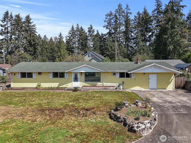 ranch-style house with driveway and a front lawn