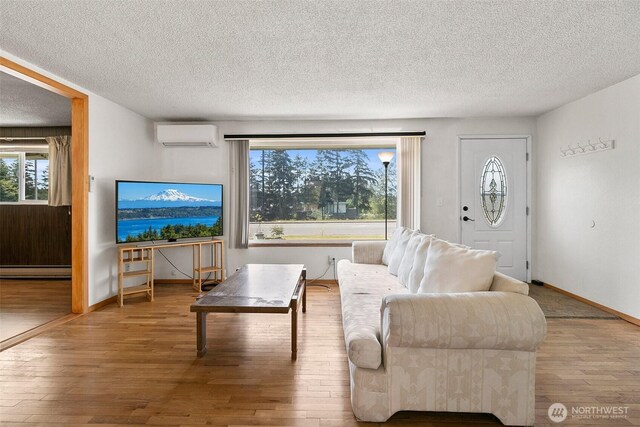 living room featuring a textured ceiling, a wealth of natural light, hardwood / wood-style floors, and a baseboard radiator