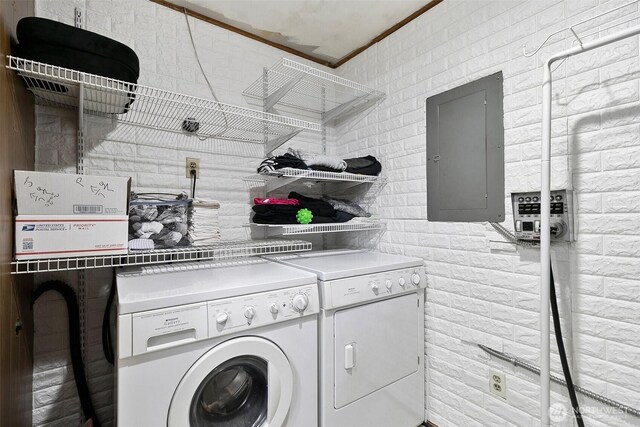 washroom featuring washer and dryer, ornamental molding, laundry area, and electric panel