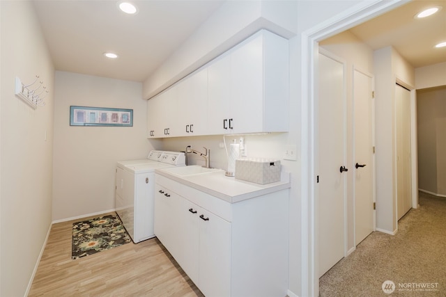 laundry area featuring cabinet space, recessed lighting, washing machine and dryer, and a sink