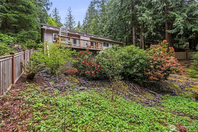 rear view of house with fence and a wooden deck