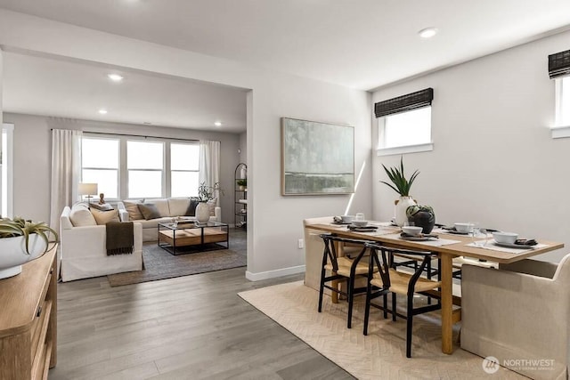 dining space with recessed lighting, a healthy amount of sunlight, and wood finished floors